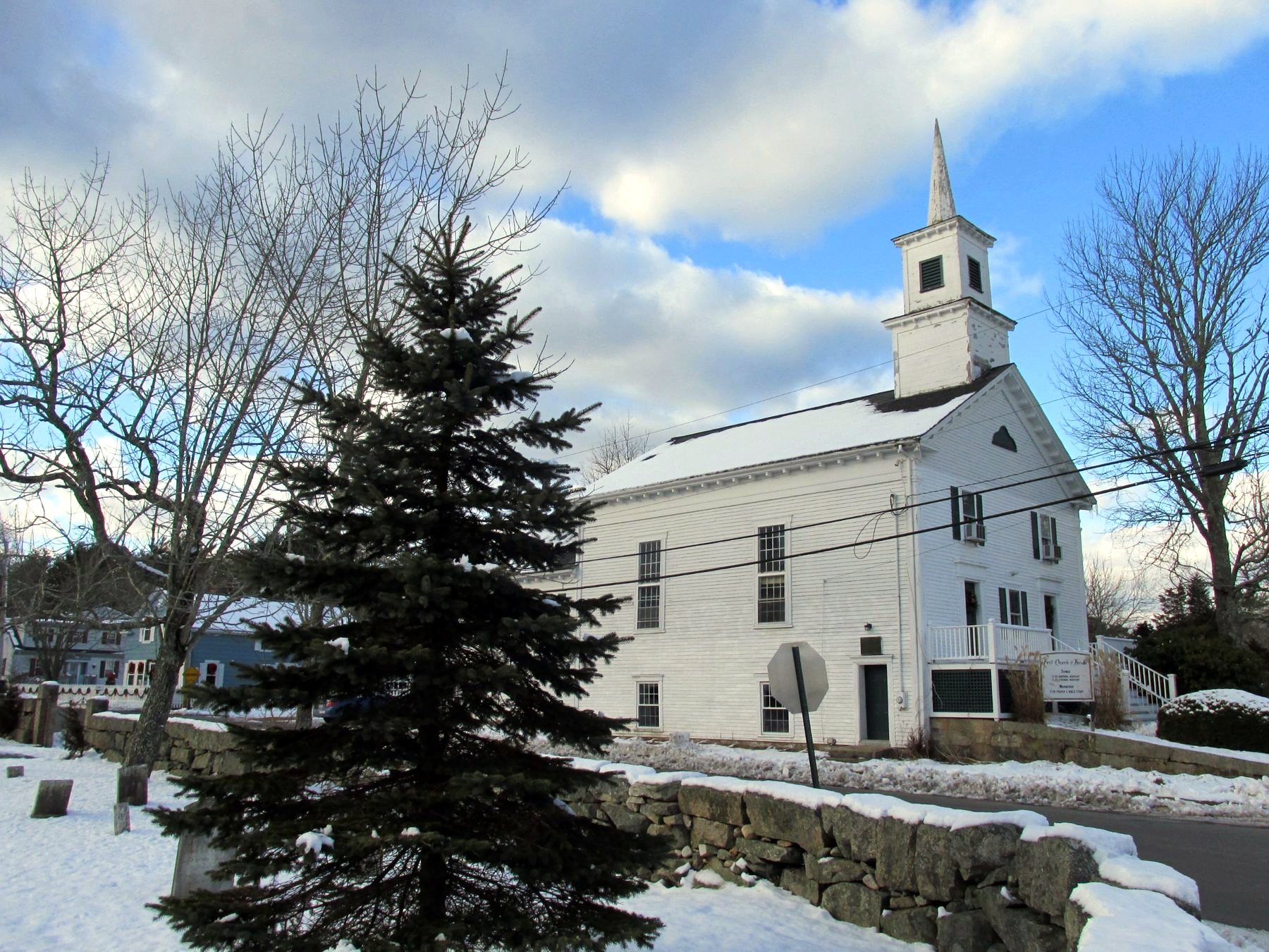 The white First Church of Hixville with its steeple, after a snowfall.