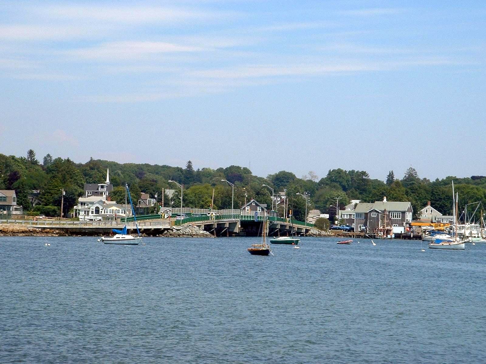 Sailboats on moorings in Padanaram Harbor with the swing bridge and village behind.